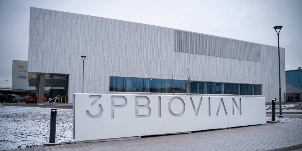 Moderni toimitilarakennus talvisessa kaupunkiympäristössä, etualalla kyltti, jossa lukee ”3PBIovian”.